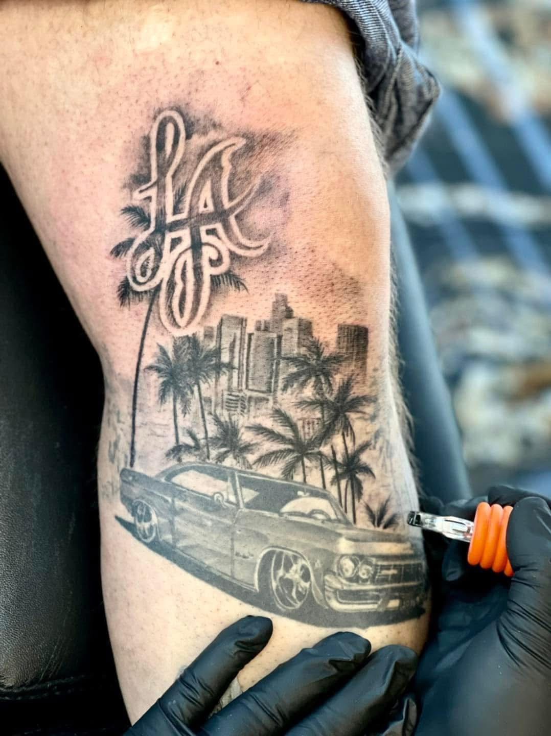 LA felirat lowrider autóval és pálmafákkal tetoválás