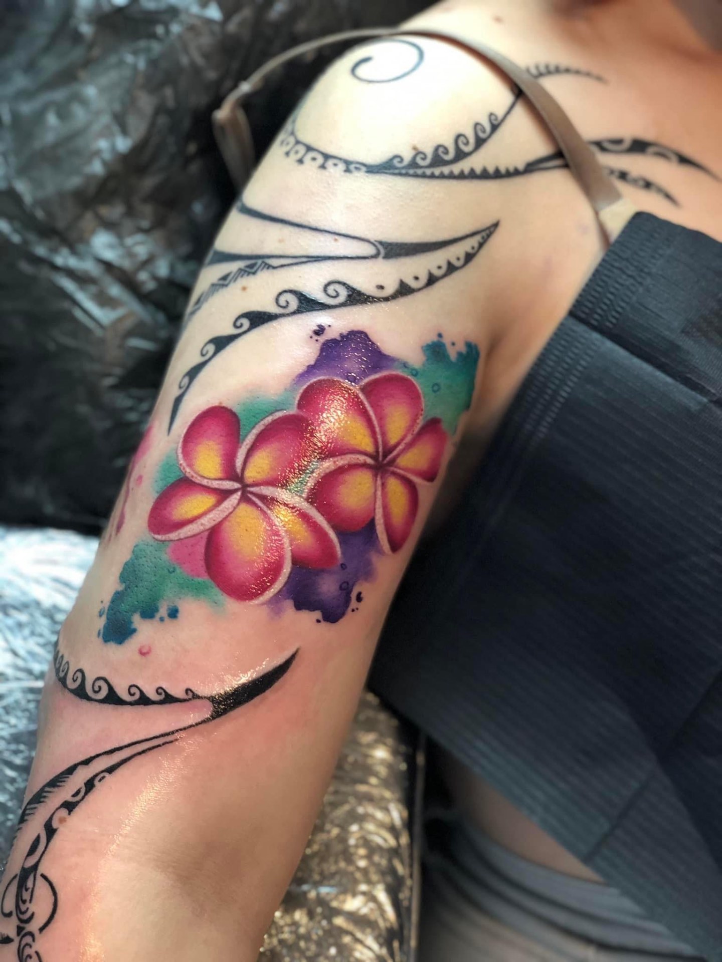 Plumeria virágok akvarell és tribal tetoválás karon